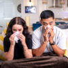 sick-couple-at-home-sniffles-together-on-couch-with-tissues-and-blanket-hiraman Facial Tissue