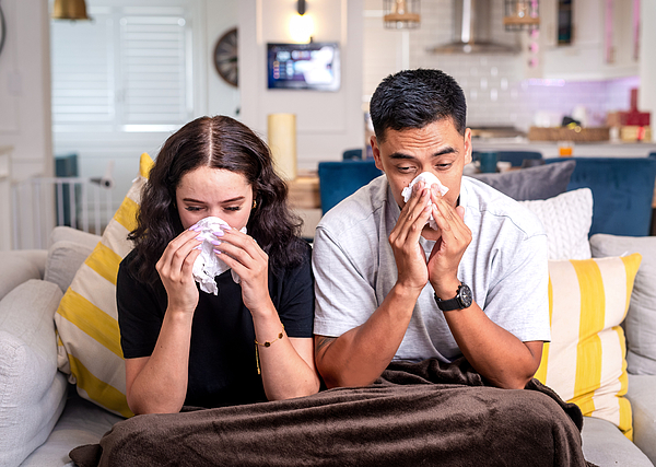 sick-couple-at-home-sniffles-together-on-couch-with-tissues-and-blanket-hiraman Facial Tissue